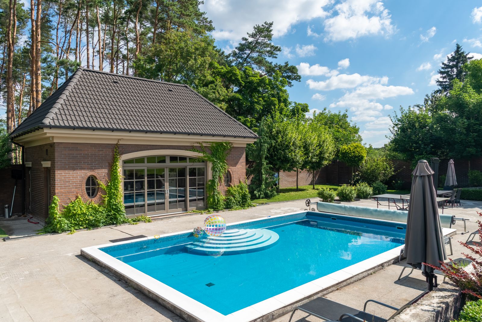 Elegant poolside setup with a modern patio, ideal for summer relaxation.